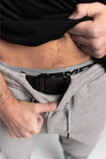 Concealed carry holster in gray pants featuring Carrier Rapid Clasp Retention Belt