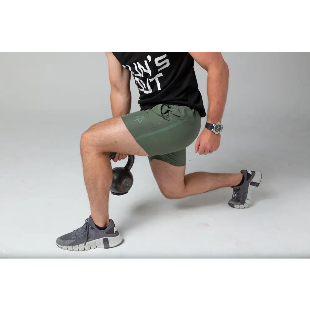 Person demonstrating a lunge in Carrier Training Shorts for concealed carry flexibility