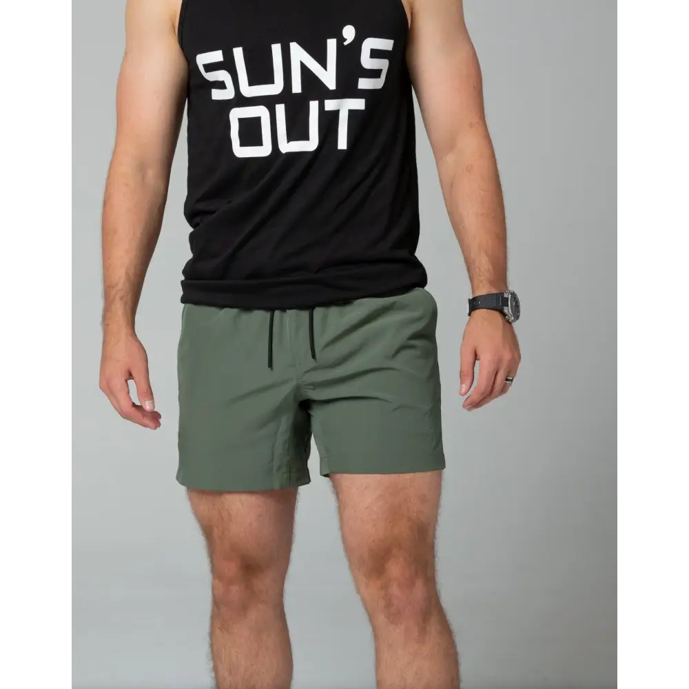 Black tank top with SUN’S OUT paired with Carrier Training Shorts in Ranger Green