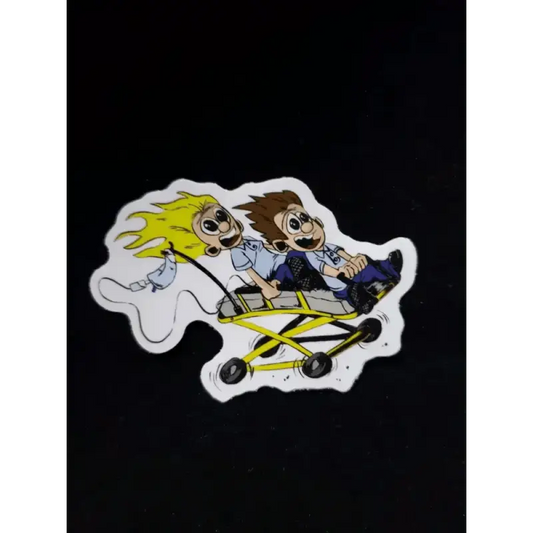 Cartoon sticker of two characters in a yellow go-kart for Real EMS, supporting first responders