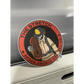 Circular red stretch sticker of a firefighter with a yellow helmet and skeleton hand design