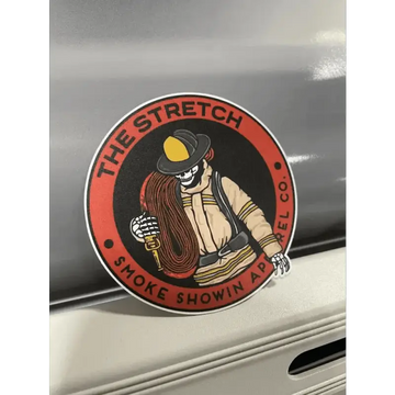 Circular red stretch sticker of a firefighter with a yellow helmet and skeleton hand design