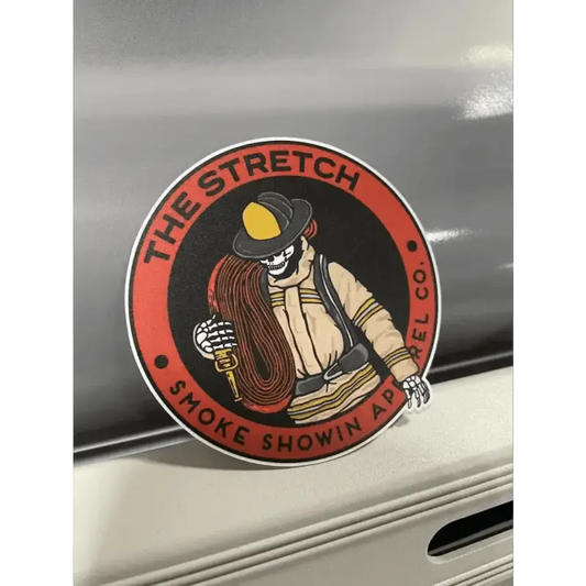 Circular red stretch sticker of a firefighter with a yellow helmet and skeleton hand design