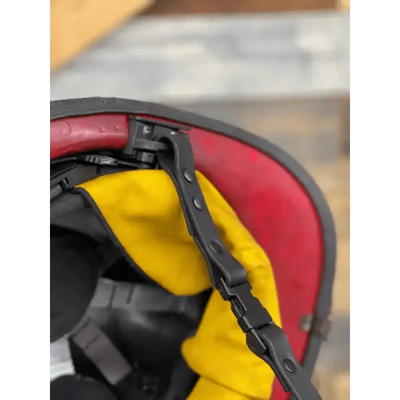 Close-up of a motorcycle helmet with red, yellow, and black panels featuring smooth leather chin straps