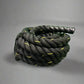 Coiled black firefighter battle rope with yellow accents and textured handle for first responders