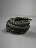 Coiled black firefighter battle rope with yellow accents and textured handle for first responders
