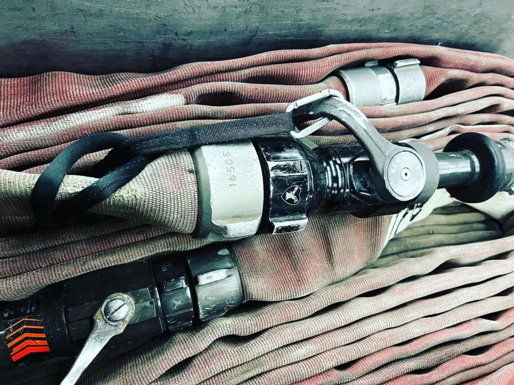 Coiled fire hose with metal coupling for FMT Lanyard Strap and girth hitching