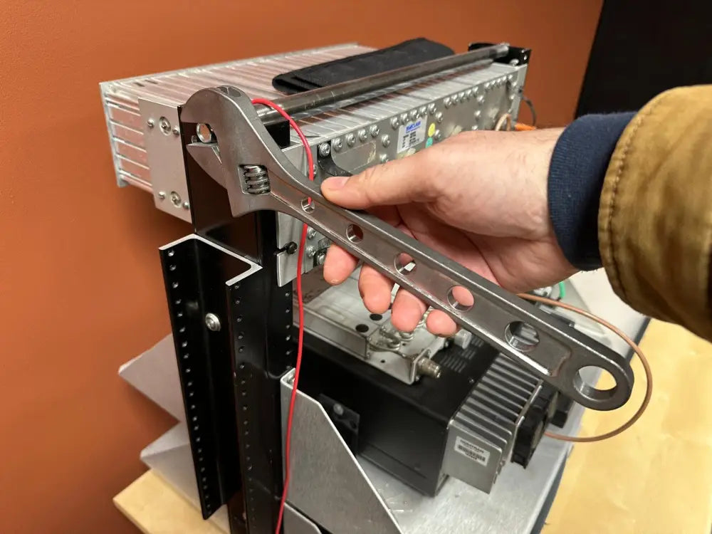 Technician servicing computer network hardware with lightweight titanium adjustable wrench