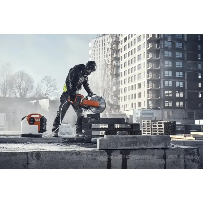 Construction worker using Husqvarna K 1 PACE battery powered rescue power cutter on rooftop