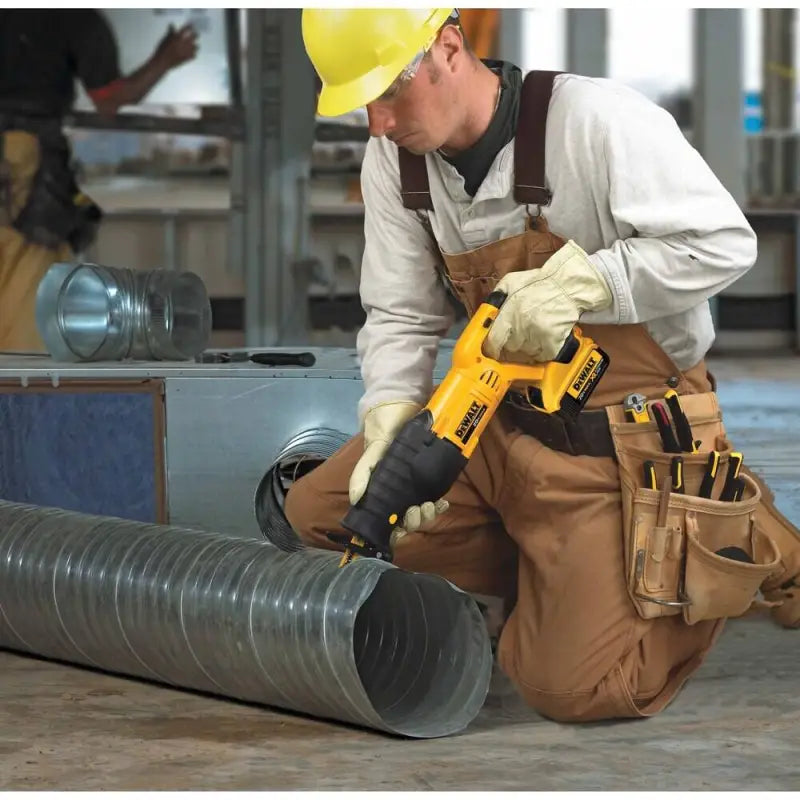 Construction worker using DEWALT DCS380B 20V MAX* Reciprocating Saw on ductwork