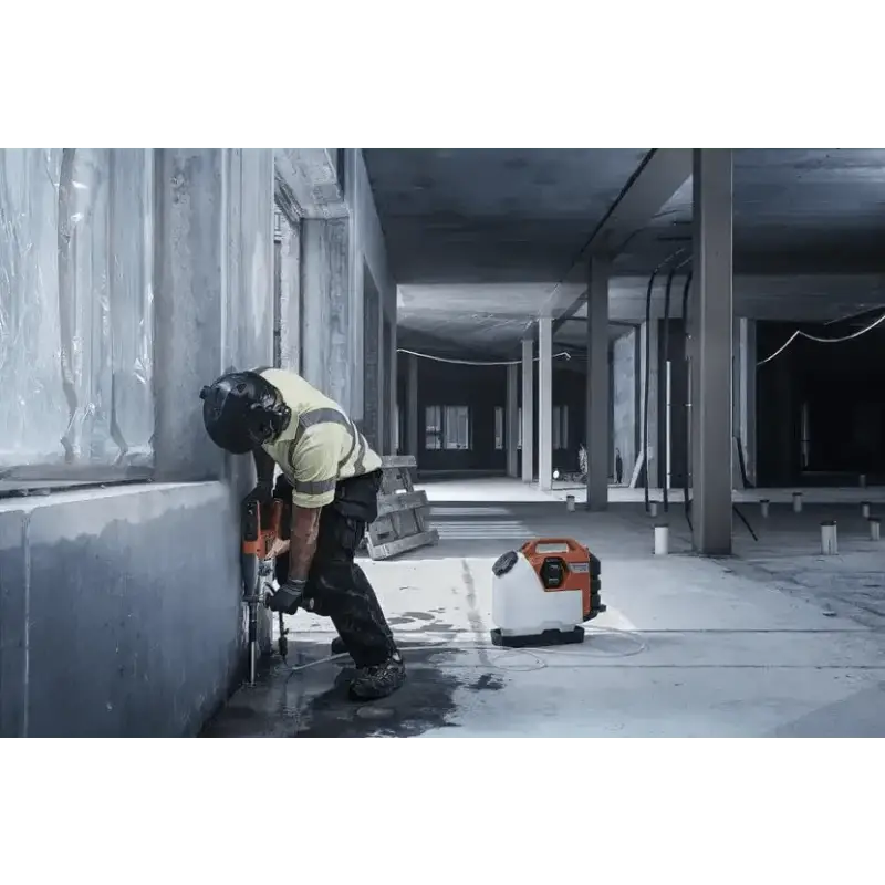 Construction worker using Husqvarna 540i battery powered core drill kit on a wall