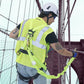 Construction worker in safety gear using a single leg internal shock-absorbing lanyard