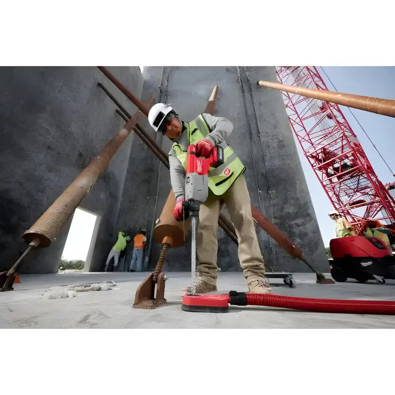 Construction worker in safety gear using Milwaukee 2916-20 M18 FUEL D-Handle Rotary Hammer