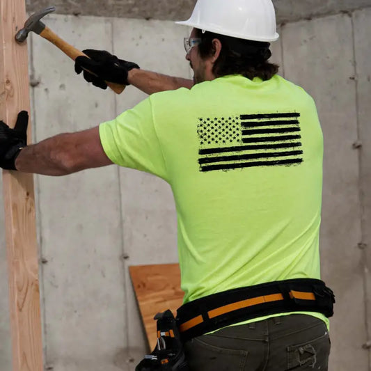 Construction worker hammering wood while wearing a Safety Yellow Hi-Vis T-Shirt