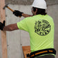 Construction worker hammering wood while wearing a Safety Yellow Hi-Vis T-Shirt