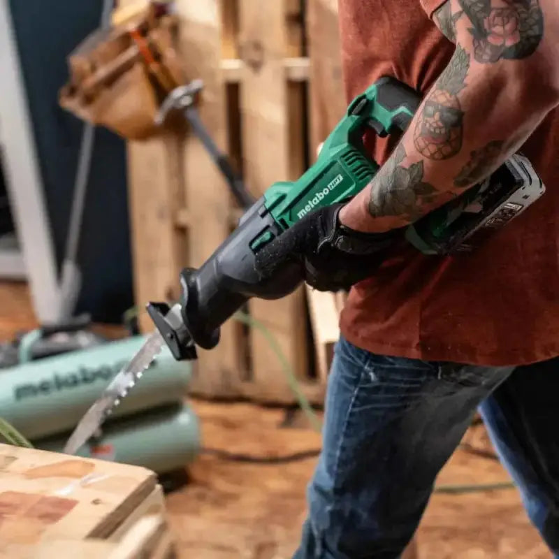 Cordless reciprocating saw held by a tattooed hand, featuring Metabo HPT CR18DBQ4M design