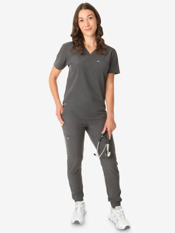 Dark gray women’s tuckable one-pocket scrub uniform with jogger-style pants and v-neck top