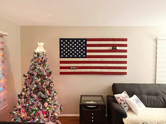 Decorated Christmas tree with pink lights beside Fire Hose Flag wall hanging