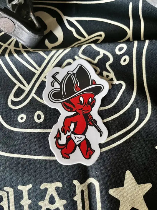 Red devil baby cartoon character in firefighter helmet for first responders sticker