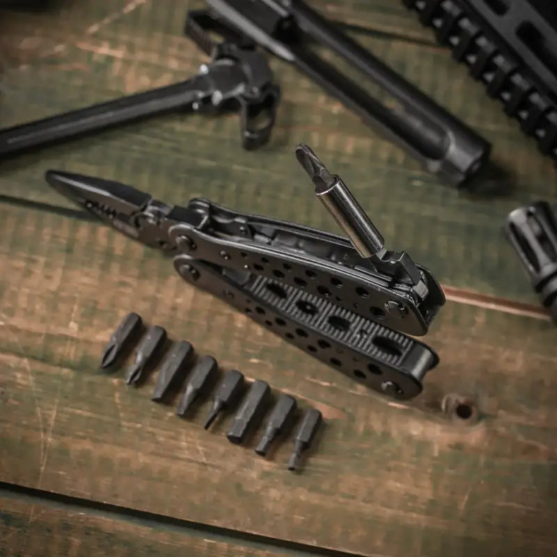 Disassembled black tactical rifle with ammunition beside M-Tac Multitool Type 1