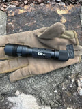 Black Powertac E9 GEN5 tactical EDC flashlight on tan work glove for enhanced grip