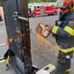 Firefighter cutting a metal door with a power saw on a Forcible Entry Door Prop