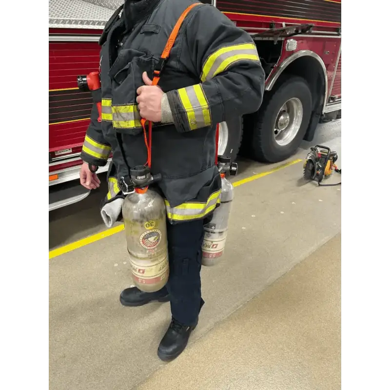 Firefighter in protective gear using SCBA Bottle Carrying Sling for carrying bottles