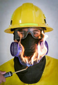 Firefighter in protective gear with flames showcasing Hot Shield HS-5 Respirator Protector Housing for enhanced nighttime visibility