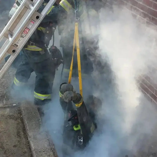 Firefighters in smoke using Multi-Loop Rescue Strap with safety equipment for rescue