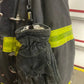 Firefighter’s protective glove hanging on turnout gear using Glove Clamp, a high-grade metal glove holder for first responders