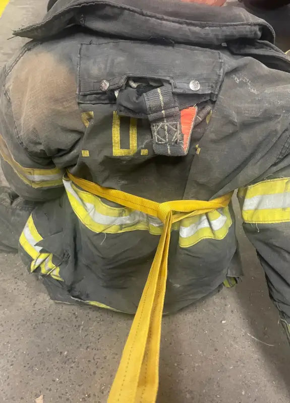 Firefighter’s turnout coat with yellow hose from Multipurpose Webbing Personal Carry Kit for fireground applications