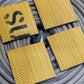 Four yellow textured hose coasters on coiled gray rope for unique man gifts