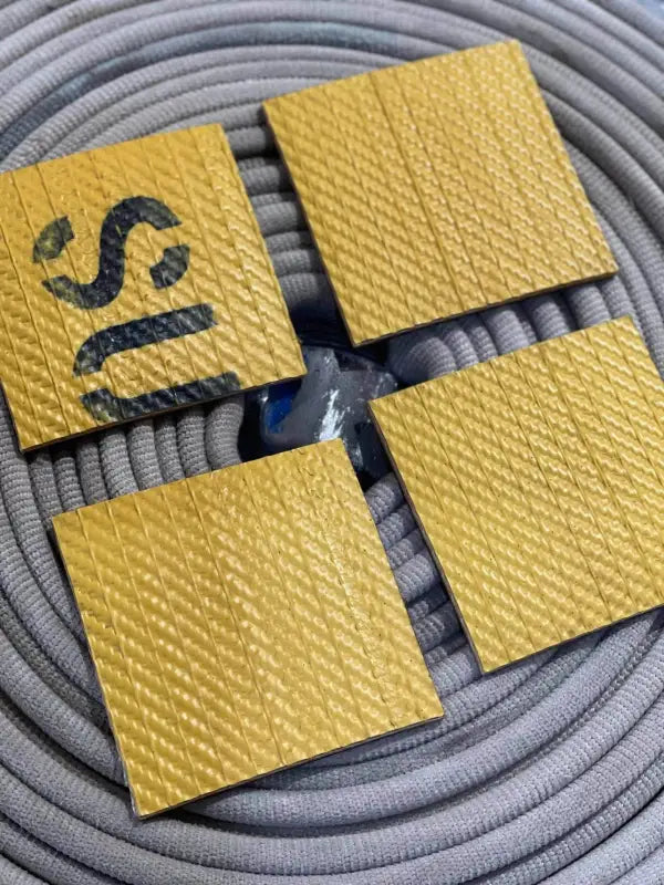 Four yellow textured hose coasters on coiled gray rope for unique man gifts