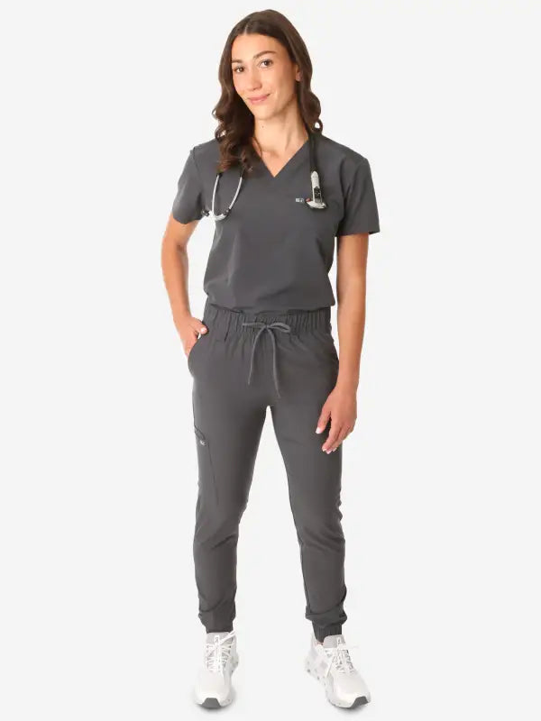 Gray women’s tuckable one-pocket scrub uniform with jogger-style pants and v-neck top