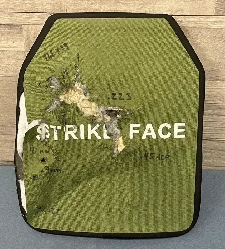 Green body armor plate with multiple impact points from various calibers in redemption tactical large size kit