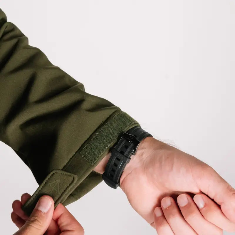 Green jacket sleeve with adjustable velcro closure on Tactical Jacket Bravo for durability