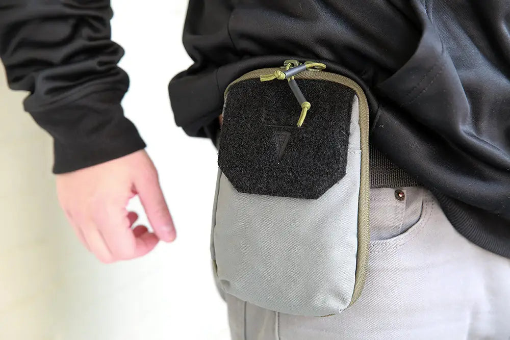 Grey waist pouch pocket organizer with black velcro flap and green zipper for first responders