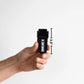 Hand holding a black pepper spray canister from the Handy Hook Firefighter Set