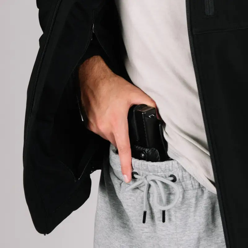 Handgun in hand pocket of Tactical Jacket Bravo for concealed carry safety
