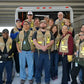 Group of workers in HCPHES Safety Vests gathered by a vehicle for safety briefing