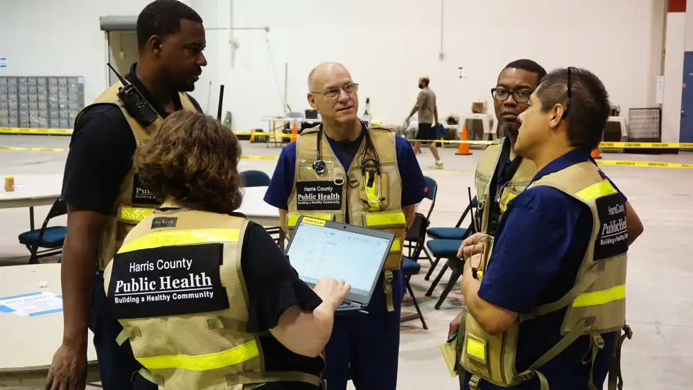 Group of emergency responders in HC PHES Safety Vests discussing safety protocols