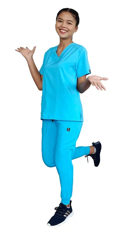 Healthcare worker in blue stretch slim fit zipper jogger uniform jumping happily