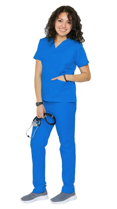 Healthcare worker in Women’s Classic 8 Pocket Uniform Scrubs with pen slot and gray shoes