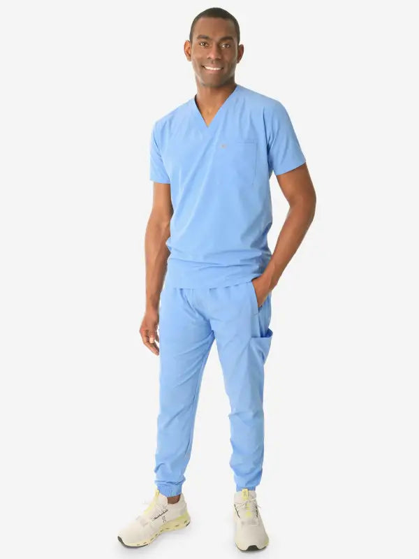 Healthcare worker in light blue medical scrubs showcasing men’s double-pocket scrub top