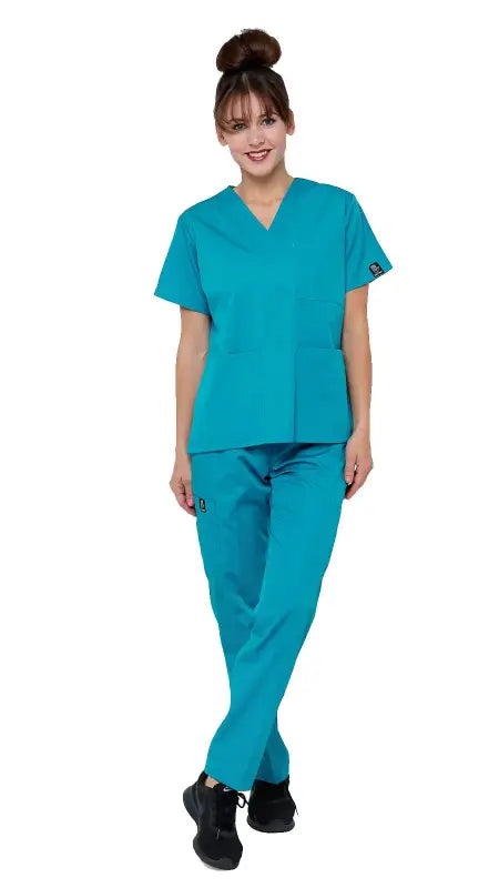 Healthcare worker in teal pocket uniform scrubs with pen slot and black shoes