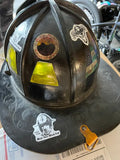 Black firefighter helmet adorned with vibrant helmet stickers for first responders
