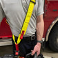 High-visibility yellow safety harness with red accents for extrication tool carrying strap