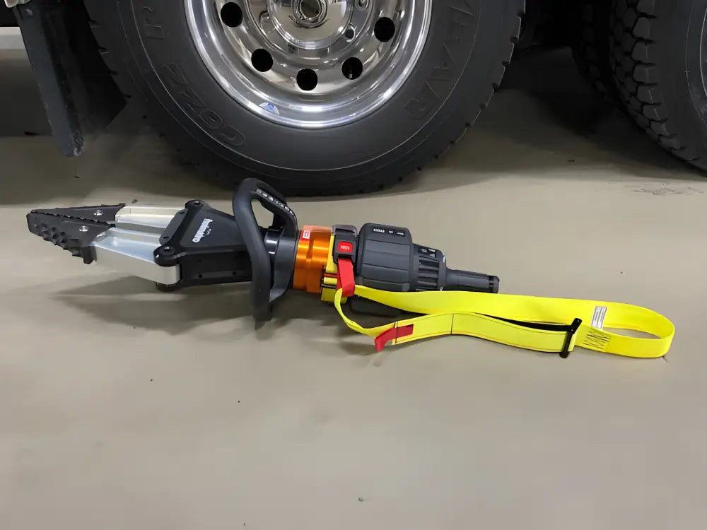 Hydraulic rescue tool with yellow strap for extrication tool carrying on truck wheel