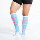 Light blue knee-high compression socks with pink flamingo patterns for marathon runners