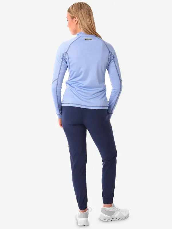 Light blue long-sleeve athletic top with navy workout pants in Women’s Scrub Jacket